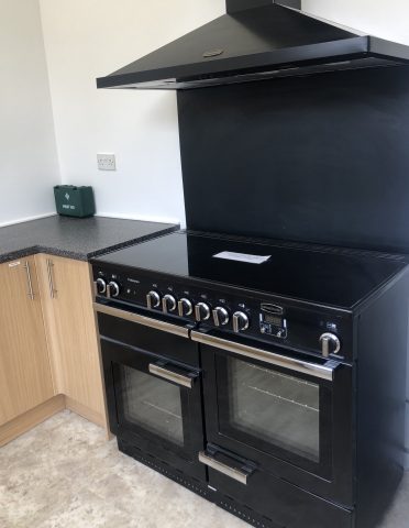 Black cooker with double oven and extractor hood